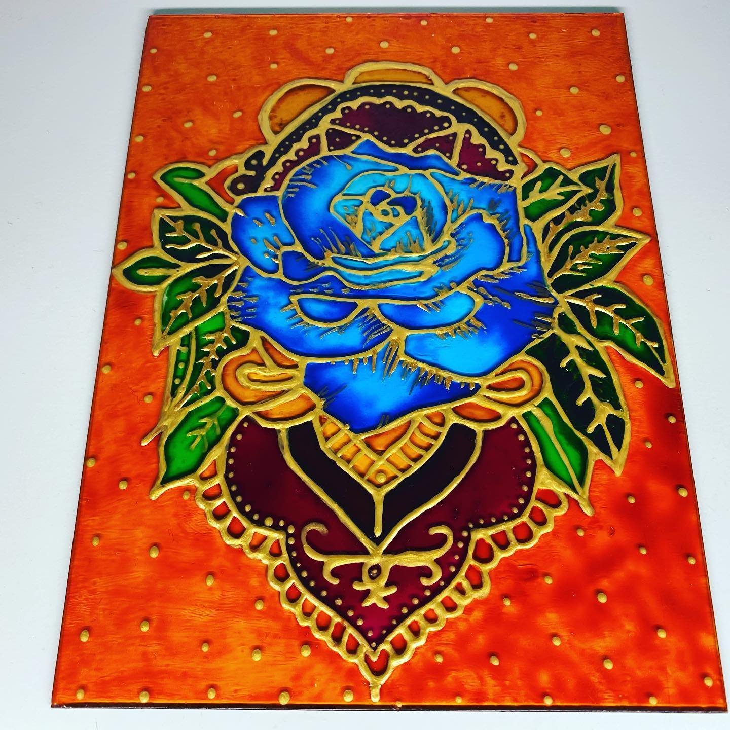 Blue rose painted on copper-toned glass