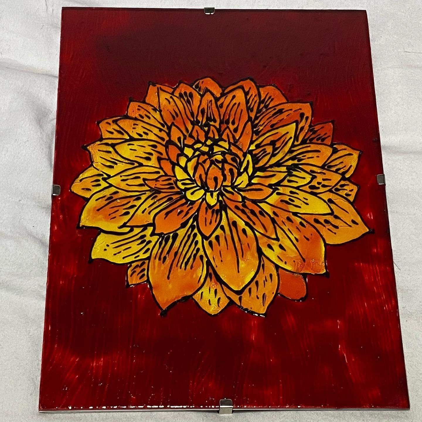 Dahlia painted in flame tones on glass